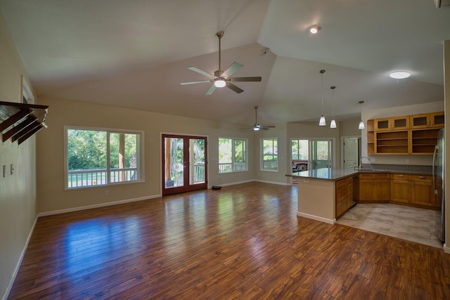 kitchen with pendant lighting, sink, dark hardwood / wood-style floors, vaulted ceiling, and kitchen peninsula