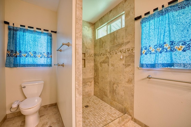 bathroom with tiled shower, tile patterned floors, and toilet