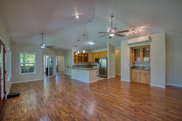 kitchen with hardwood / wood-style flooring, stainless steel appliances, a wall mounted AC, and hanging light fixtures