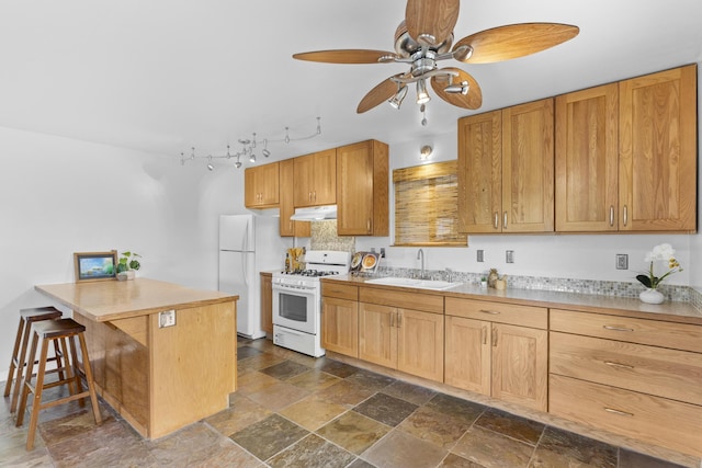 kitchen featuring kitchen peninsula, ceiling fan, sink, white appliances, and a kitchen bar