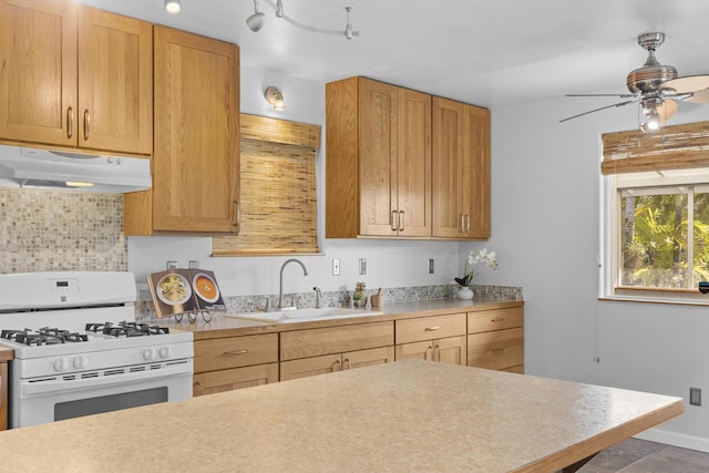 kitchen featuring white gas range, ceiling fan, rail lighting, and sink