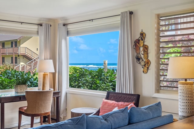 living area with crown molding, a healthy amount of sunlight, and a water view