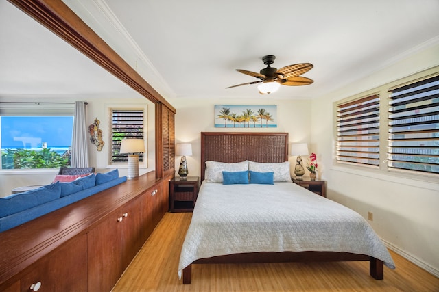 bedroom with light wood-type flooring, ceiling fan, and ornamental molding