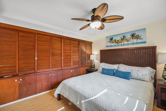 bedroom with light wood-type flooring, ceiling fan, and ornamental molding