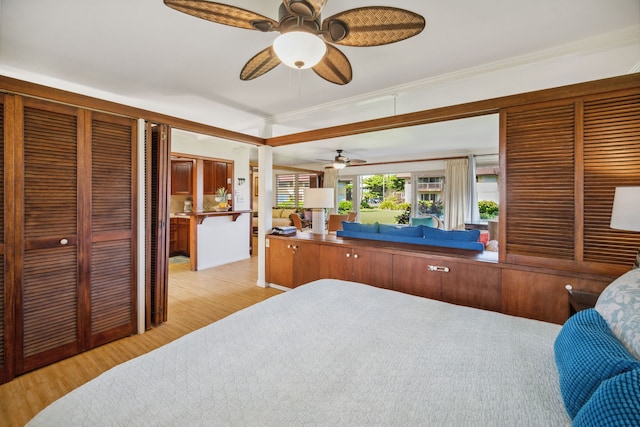 bedroom featuring ceiling fan, crown molding, and light hardwood / wood-style flooring