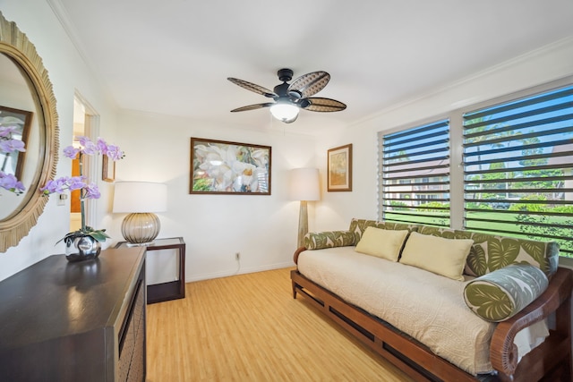 interior space featuring ceiling fan, light wood-type flooring, and crown molding