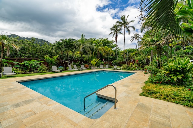 view of swimming pool with a mountain view and a patio area