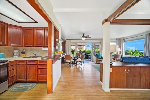 kitchen with stainless steel range with electric cooktop, decorative backsplash, light hardwood / wood-style floors, ceiling fan, and crown molding