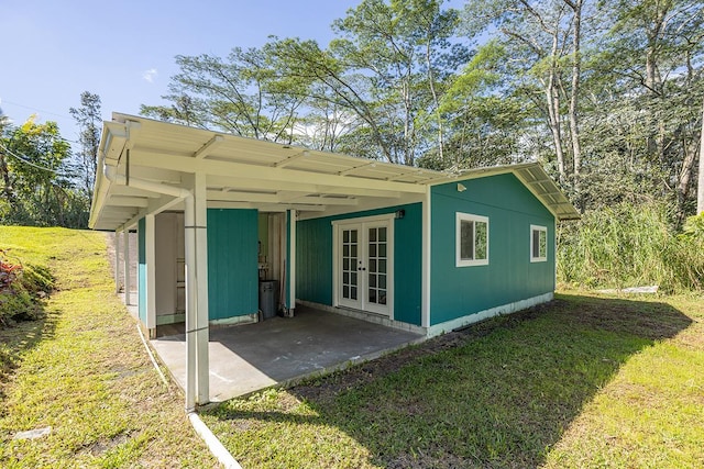 back of property with french doors and a yard