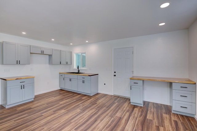 kitchen featuring dark hardwood / wood-style floors, sink, butcher block countertops, and gray cabinetry