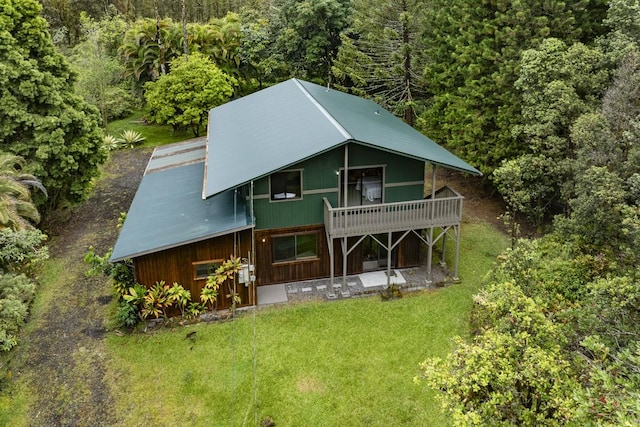 rear view of property featuring a deck and a lawn