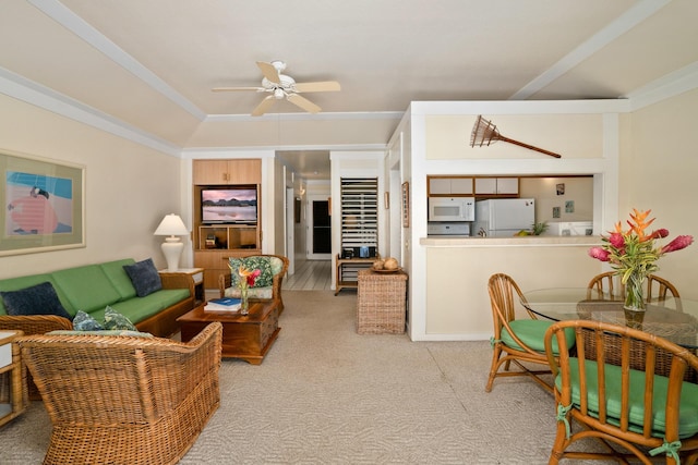 living room with ceiling fan, crown molding, and light colored carpet