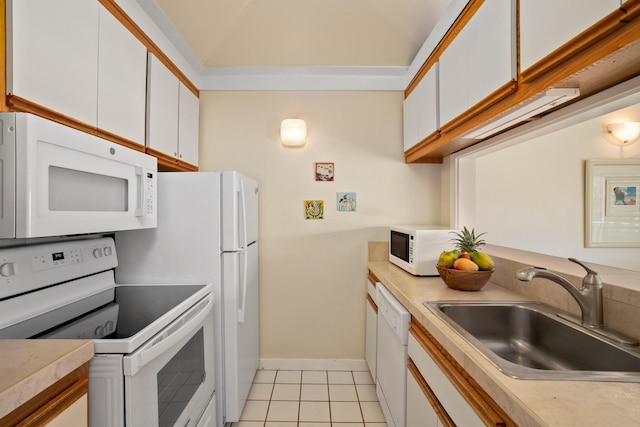 kitchen featuring light tile patterned floors, sink, white cabinets, and white appliances