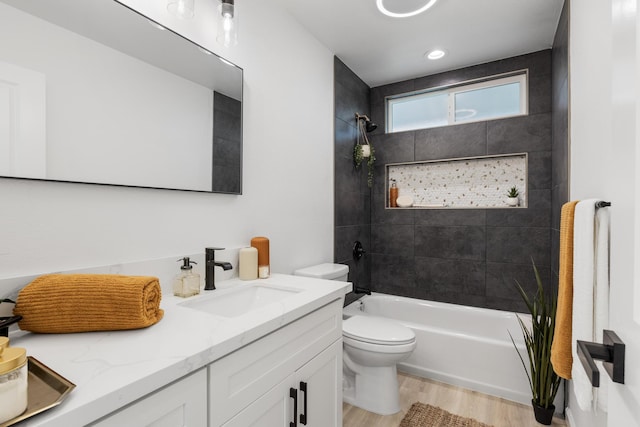 full bathroom featuring vanity, toilet, tiled shower / bath combo, and wood-type flooring