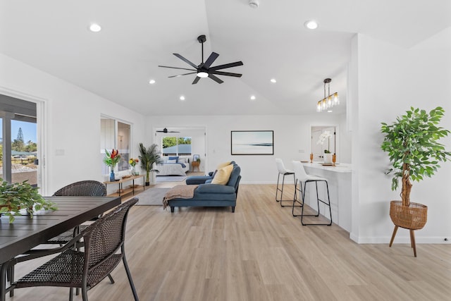 living room featuring ceiling fan, vaulted ceiling, and light wood-type flooring