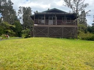 rear view of house with a deck and a yard