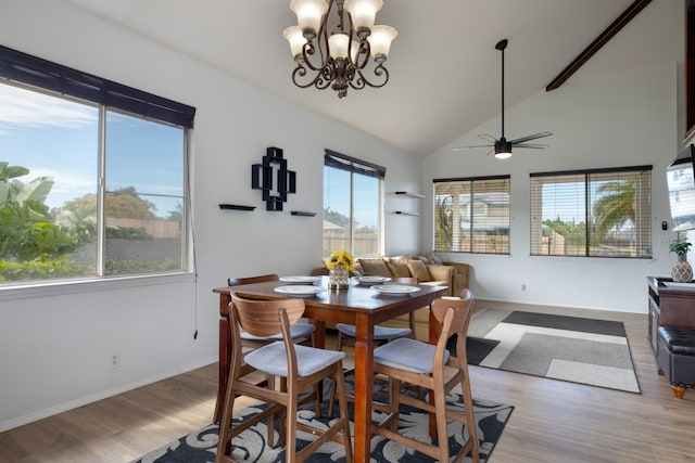 dining room featuring lofted ceiling, light wood-type flooring, and ceiling fan with notable chandelier