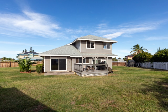 rear view of house with a lawn and a deck