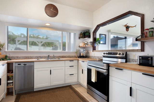 kitchen with white cabinets, wood counters, and stainless steel appliances