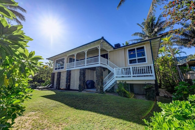 back of property with a yard and a sunroom