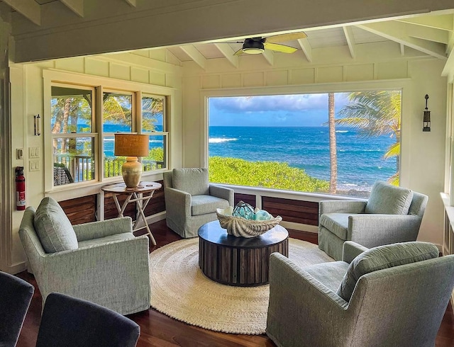 sunroom / solarium with ceiling fan, a water view, and vaulted ceiling with beams