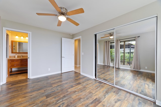 unfurnished bedroom featuring ceiling fan, ensuite bath, dark hardwood / wood-style floors, and a closet