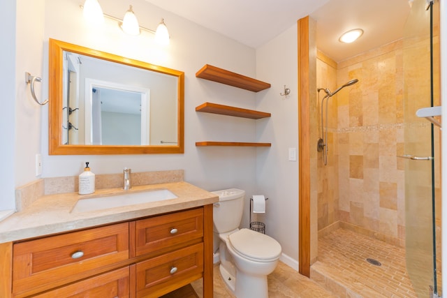 bathroom featuring tiled shower, vanity, and toilet