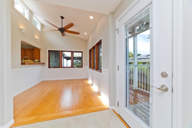 entryway with ceiling fan, lofted ceiling, light tile patterned floors, and a wealth of natural light