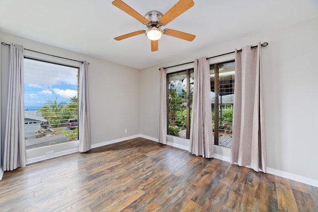 unfurnished room featuring dark hardwood / wood-style flooring, plenty of natural light, and ceiling fan