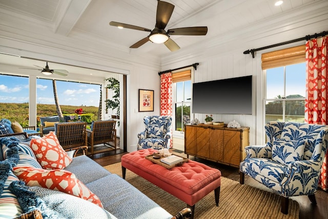 living room featuring ceiling fan, ornamental molding, beam ceiling, and hardwood / wood-style floors