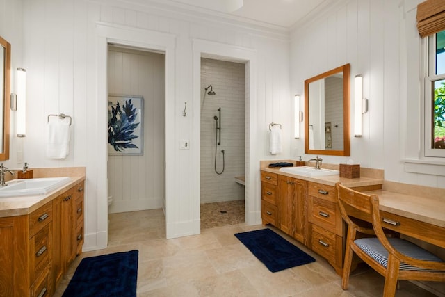 bathroom featuring crown molding, vanity, and a tile shower