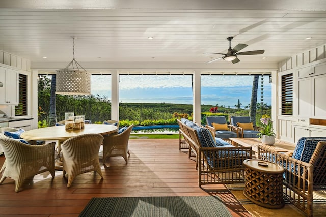 sunroom / solarium featuring plenty of natural light and ceiling fan