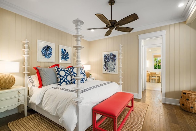 bedroom featuring dark hardwood / wood-style flooring, ornamental molding, and ceiling fan