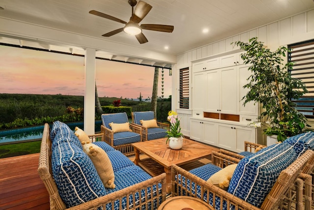 patio terrace at dusk with ceiling fan and a deck