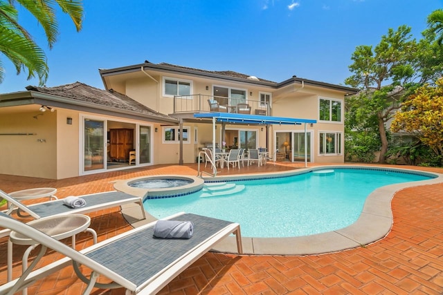 view of swimming pool featuring an in ground hot tub and a patio