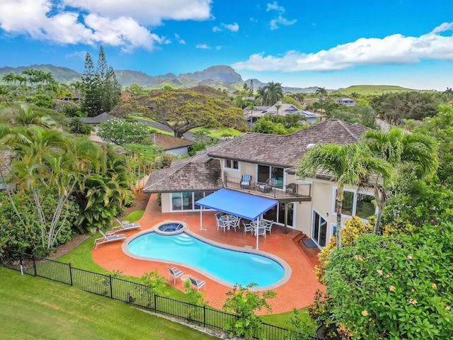 view of swimming pool with a patio, a mountain view, a yard, and an in ground hot tub