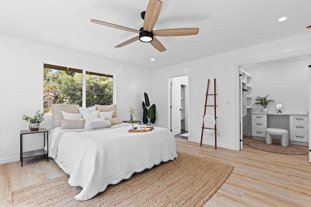 bedroom featuring baseboards, a spacious closet, light wood finished floors, and recessed lighting