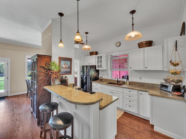 kitchen featuring sink, black appliances, and white cabinets