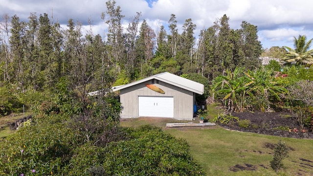 view of outbuilding with a garage and a lawn