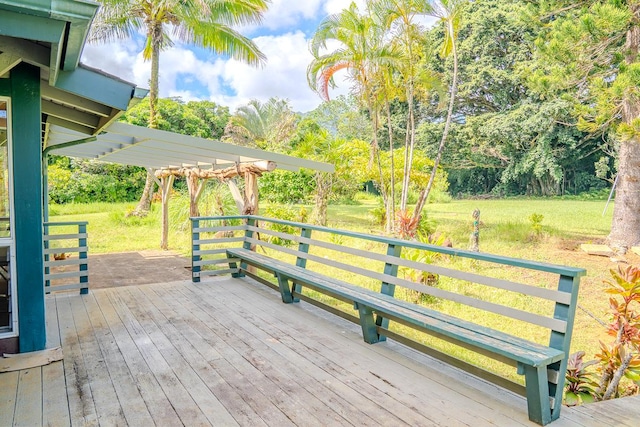 wooden terrace featuring a pergola and a lawn