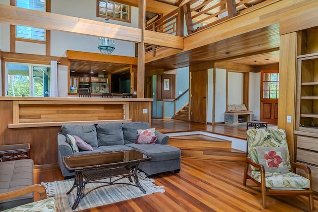 living room with hardwood / wood-style flooring, a high ceiling, and wooden walls