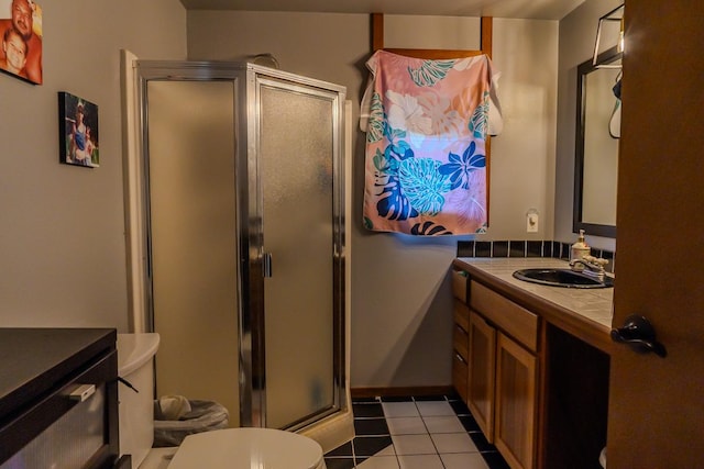 bathroom featuring toilet, tile patterned flooring, an enclosed shower, and vanity