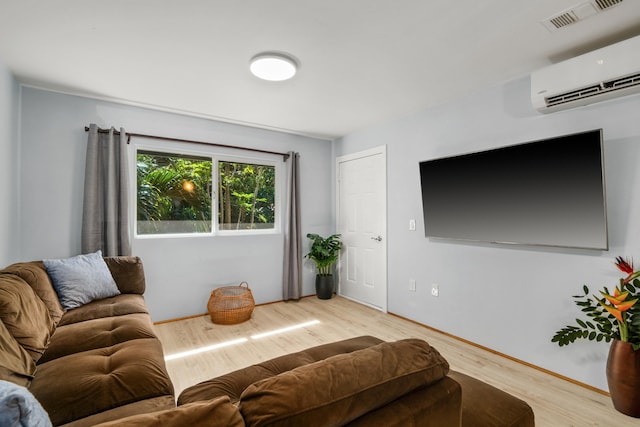 living room with light wood-type flooring and an AC wall unit