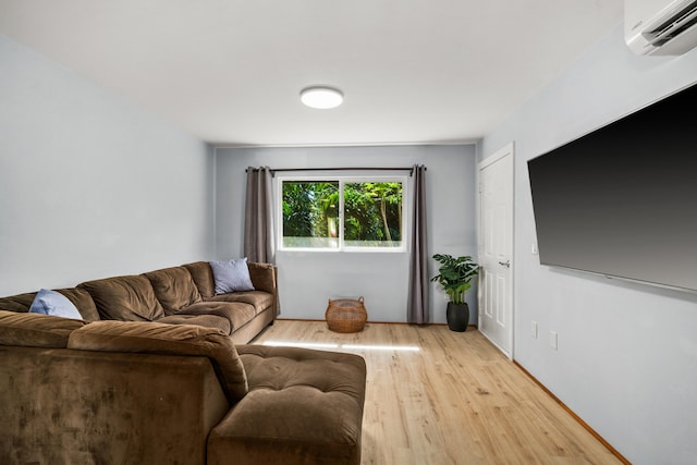 living room featuring light wood-type flooring and a wall unit AC