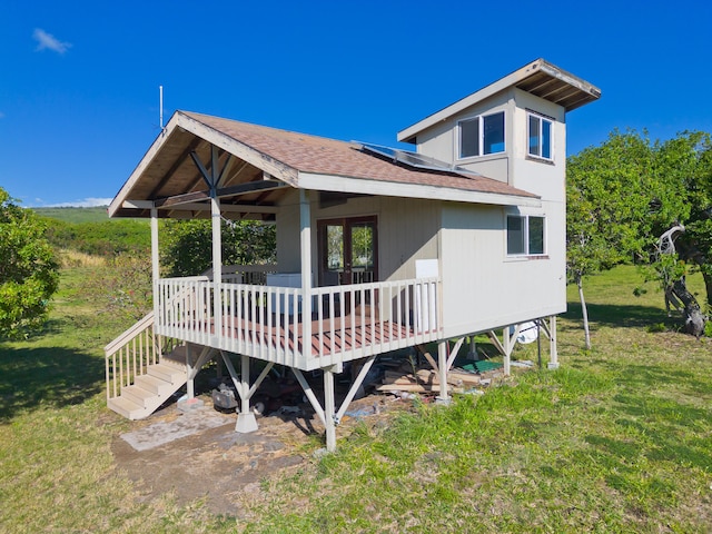 back of property featuring a deck and a lawn