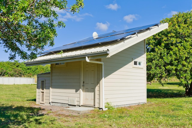 back of property featuring solar panels and a yard