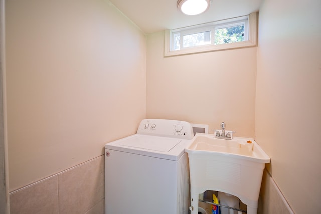 clothes washing area with washer / clothes dryer and sink