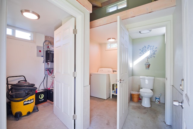 bathroom featuring washer / dryer, toilet, concrete flooring, and sink