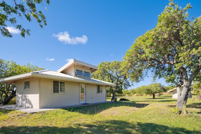 rear view of property featuring a yard