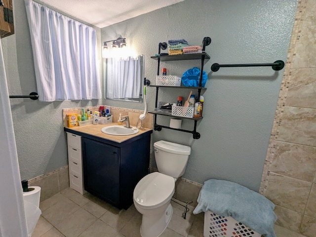 bathroom featuring vanity, tile patterned flooring, and toilet